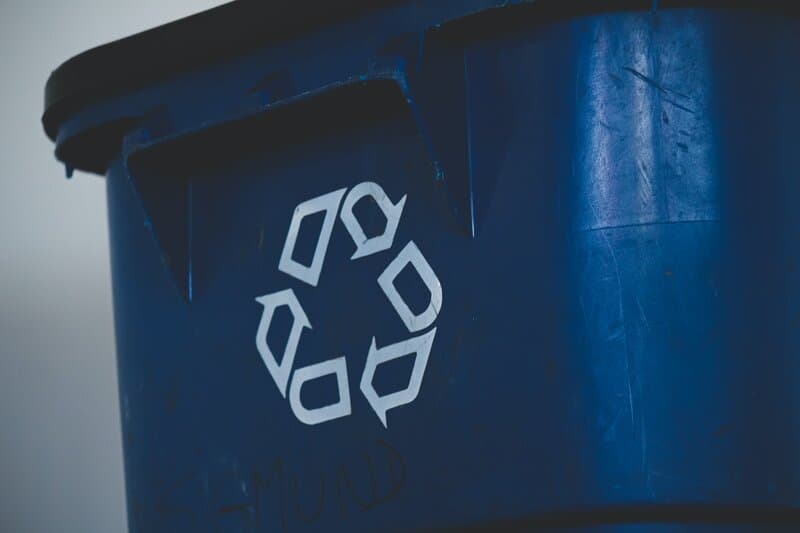 Blue bin with recycling logo on it